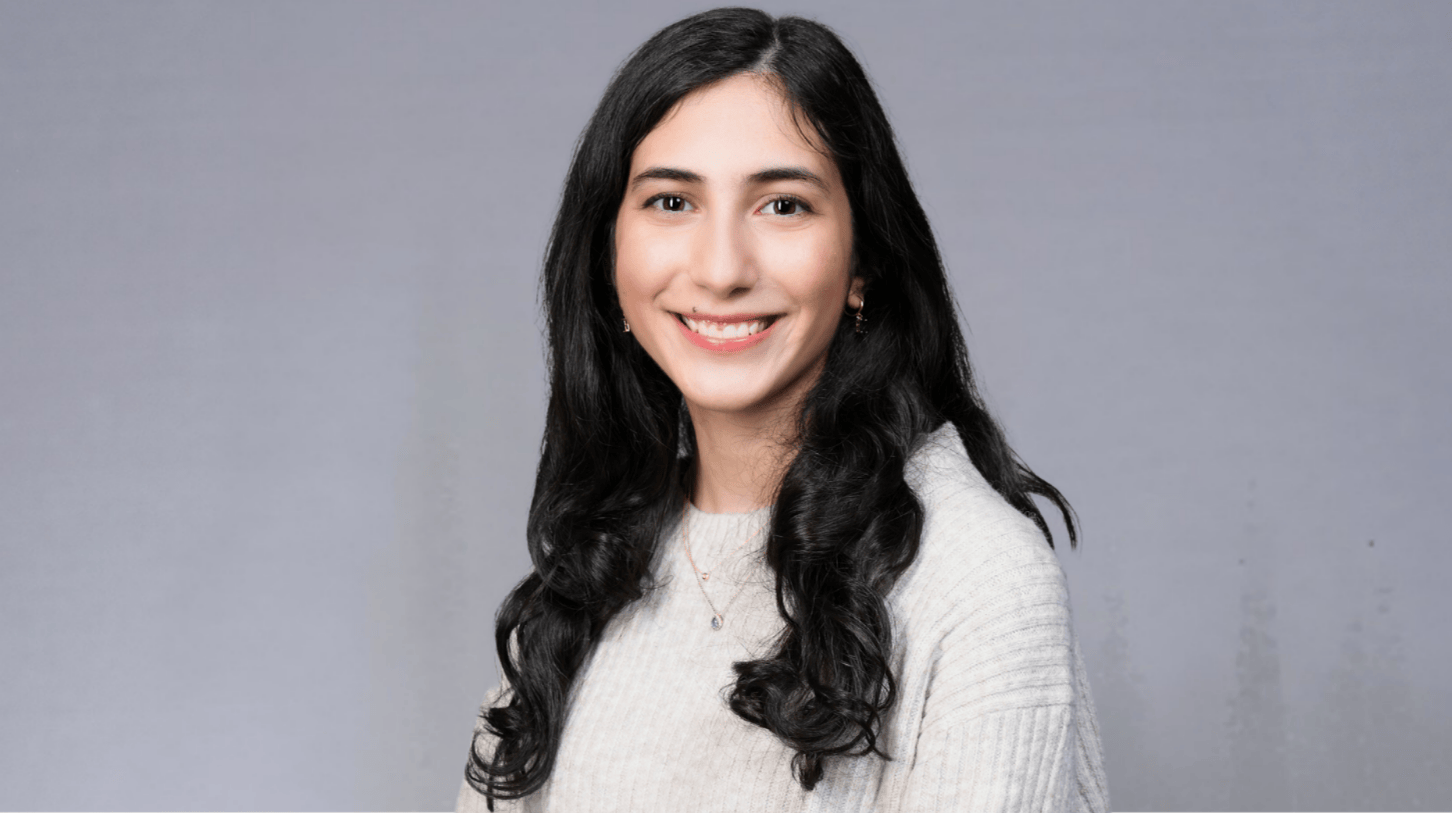 Portrait of Loyola University Chicago student smiling against gray background